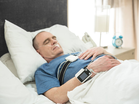 Homem realizando exame domiciliar de polissonografia para detectar apneia do sono 