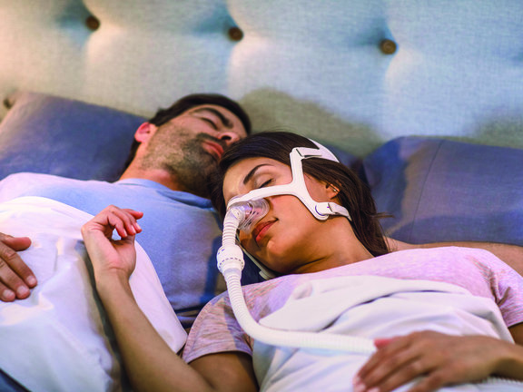 Homem e mulher com CPAP dormindo juntos