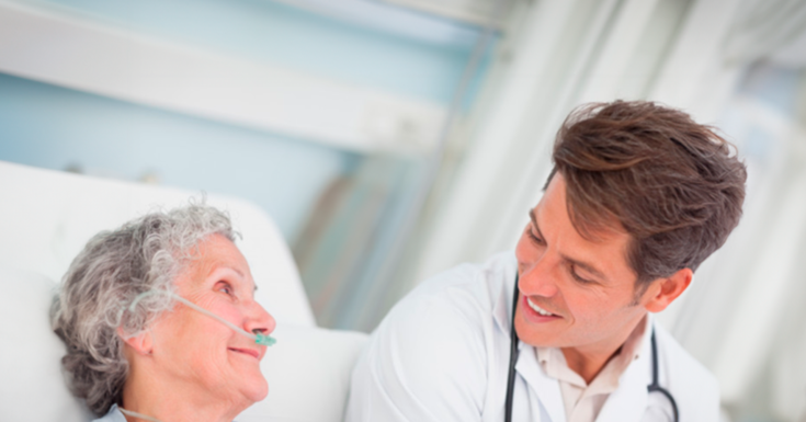 Mulher idosa em uso de oxigenoterapia recebendo orientações médicas